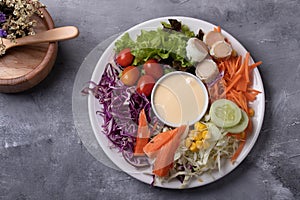 Mixed green salad, thick dressing in white plate