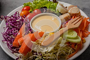 Mixed green salad, thick dressing in white plate