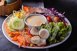 Mixed green salad, thick dressing in white plate