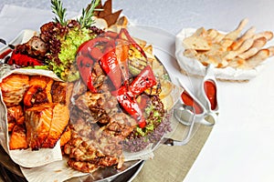 Mixed grill meat, fried vegetables and grilled salmon fish fillets decoration in warm dish