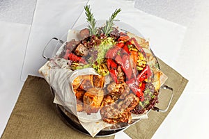 Mixed grill meat, fried vegetables and grilled salmon fish fillets decoration in warm dish