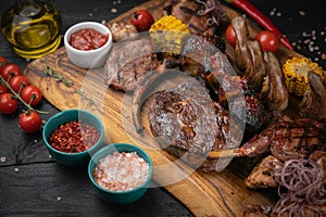 Mixed grilled meat platter on a black background