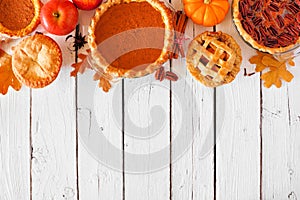 Mixed homemade autumn pies. Pumpkin, apple and pecan. Top border on a white wood background.