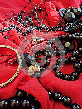 Mixed jewellery on red fabric passion for beauty