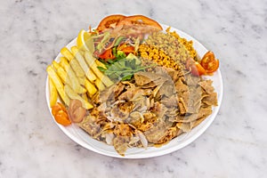 Mixed kebab plate with roast chicken and lamb meat, fried potatoes, bulgur stew with vegetables