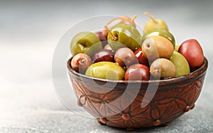 Mixed marinated olives green, black and purple in ceramic bowl and olive oil