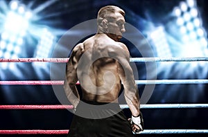 Mixed martial artist posing in the ring against spotlights. Concept of mma, ufc, thai boxing, classic boxing