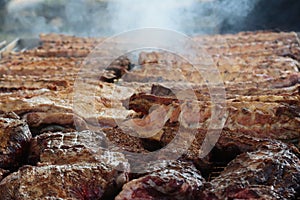 mixed meat in quantity on the grill to cook