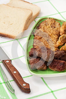 Mixed meat served with bread and a knife and fork