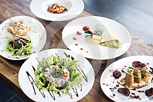 Mixed modern gourmet fusion food dishes on table