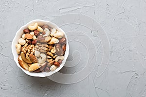 mixed nuts in bowl. Mix of various nuts on colored background. pistachios, cashews, walnuts, hazelnuts, peanuts and
