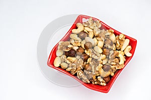 Mixed nuts in red bowl isolated