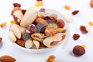 Mixed nuts and sultanas on a plate on a white background