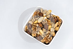 Mixed nuts in white bowl isolated