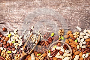 Mixed nuts on wooden table top view. Healthy food and snack