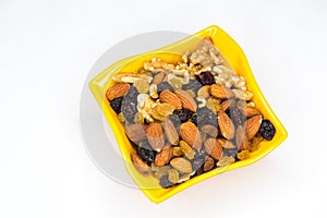 Mixed nuts in yellow bowl isolated