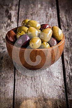 Mixed olives in a bowl on a rustic table