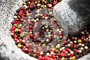 Mixed peppercorn seeds in granite pestle or mortar