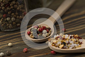 Mixed of peppers hot, red, black, white and dry coriander  in wood spoon  on wood background