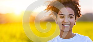 Mixed Race African American Girl In a Field of Yellow Flowers at Sunset or Sunrise