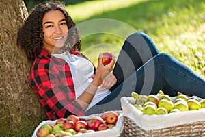 Mixed Race African American Girl Teenager Eating Apple by Tree