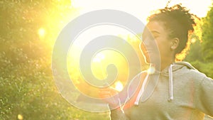 Mixed race African American girl teenager girl young woman blowing dandelion at sunset