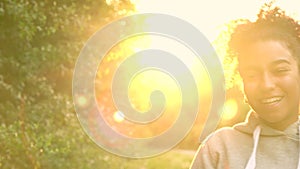 Mixed race African American girl teenager girl young woman blowing dandelion at sunset