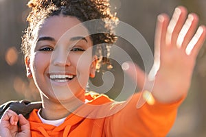 Mixed Race African American Girl Teenager Waving and Laughing in Evening Sunshine