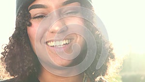 Mixed race African American girl teenager young woman laughing backlit by the sun in e