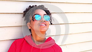 Mixed race African American girl young woman wearing sunglasses reflecting blue sky and clouds