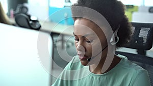 Mixed race African American woman with headset using computer, talking, working customer support service operator