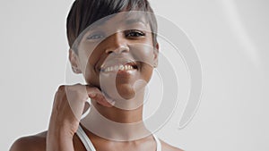 Mixed race black woman in studio watching to the camera and smiling