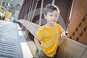 Mixed Race Boy Leaning on Bridge Outdoors