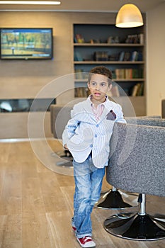 mixed race boy in a striped jacket and sneakers in