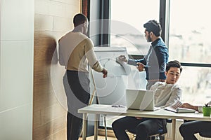 Mixed race business men in open space office interior with a panoramic window