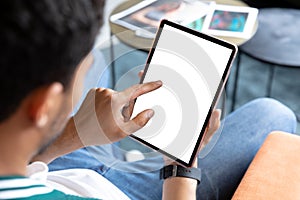 Mixed race businessman using tablet with blank screen in creative office