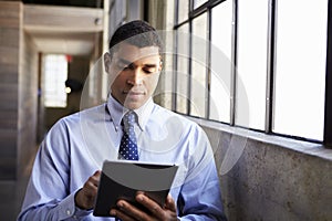 Mixed race businessman using tablet computer