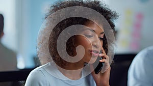 Mixed race businesswoman talking on mobile phone with business partner in office