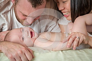Mixed Race Chinese and Caucasian Baby Boy Laying In Bed with His Parents