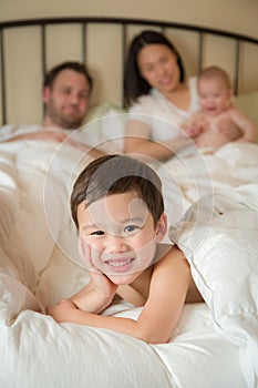 Mixed Race Chinese and Caucasian Boy Laying In Bed with His Father and Mother