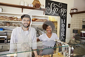 Mixed race couple behind counter at sandwich bar, close up