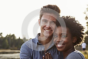 Mixed race couple in the countryside, looking to camera