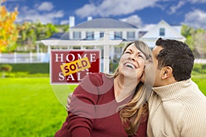 Mixed Race Couple in Front of Sold Real Estate Sign