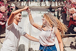 Mixed race couple in love dancing on city street. Young people having fun outdoors