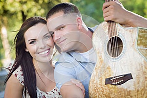 Mixed Race Couple Portrait with Guitar in Park