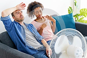 Mixed race couple trying to relief from summer heat wave