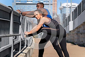 Mixed race, diverse multi ethnic fitness and exercise group, couple of male and female friends stretching before an urban street w