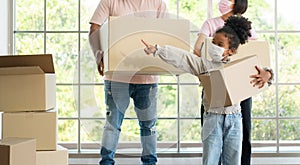 Mixed Race families are carrying cardboard boxes and walking from the front door into the house in a new house on moving day.
