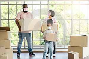 Mixed Race families are carrying cardboard boxes and walking from the front door into the house in a new house on moving day.