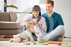 Mixed race family with baby son playing at home